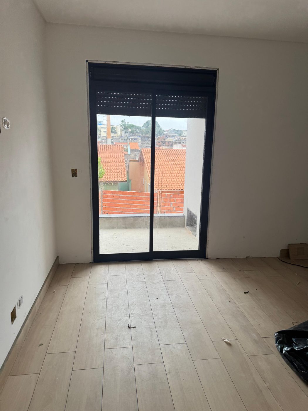 Ambiente com porta de vidro e alumínio dando para a varanda